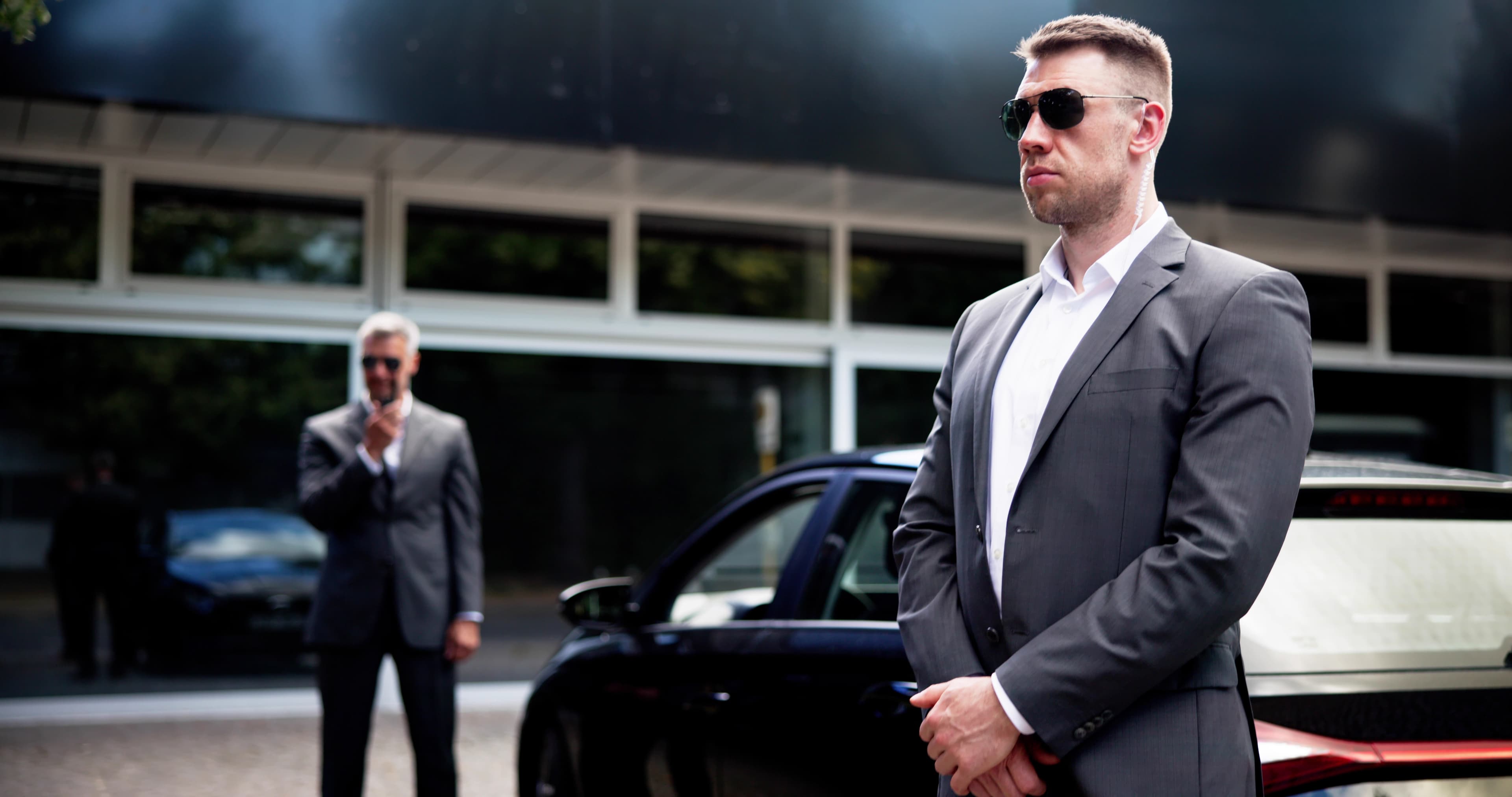 Security Guard schützt Executive am Luxusfahrzeug